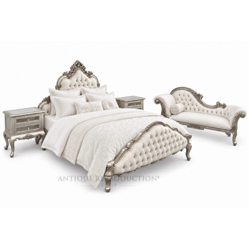 Luxury French Provincial upholstered bed frame in an antique silver finish with ivory button tufting, shown with optional matching bedside tables and chaise lounge.