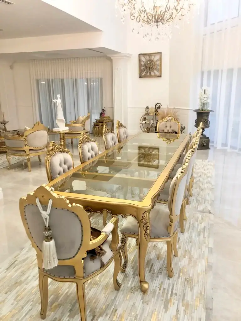This is a photo of the French Provincial dining table paired with upholstered dining chairs in an antique gold finish