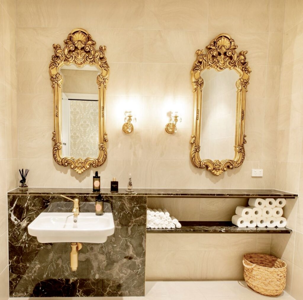 his is an image of the mirrors, powder rooms & makeup areas featuring custom-designed restroom and powder room mirrors, and french carved antique gold consoles as makeup tables.
