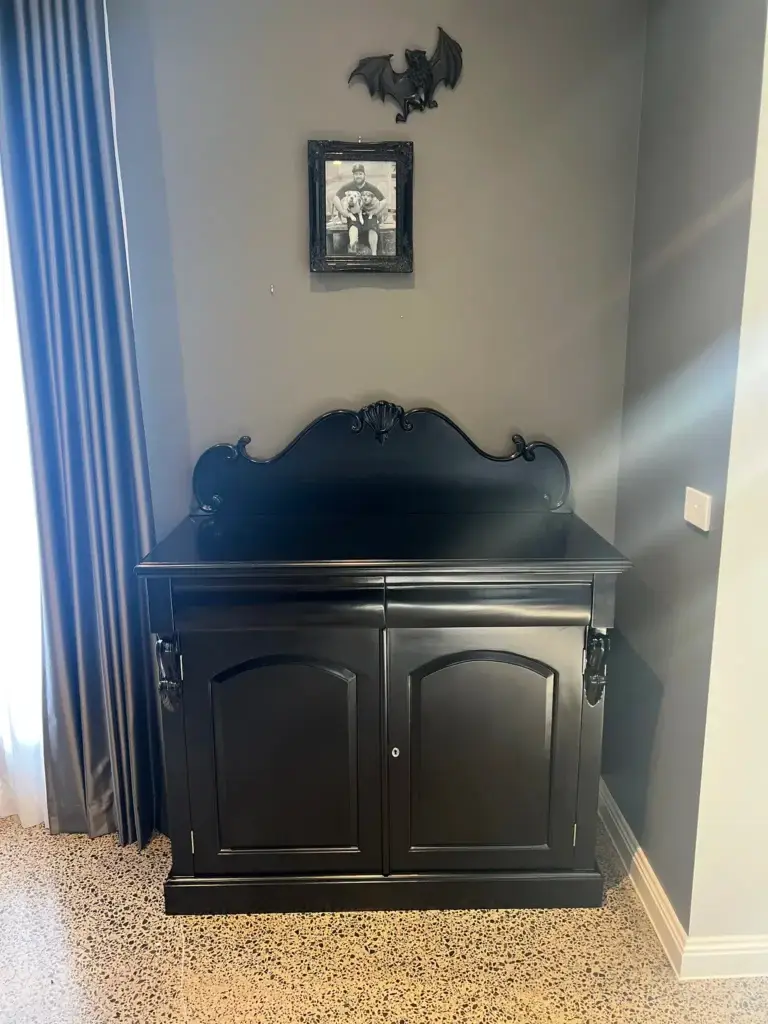 This is an image of a Black Timber cabinet on a polished concrete floor with Green olive walls