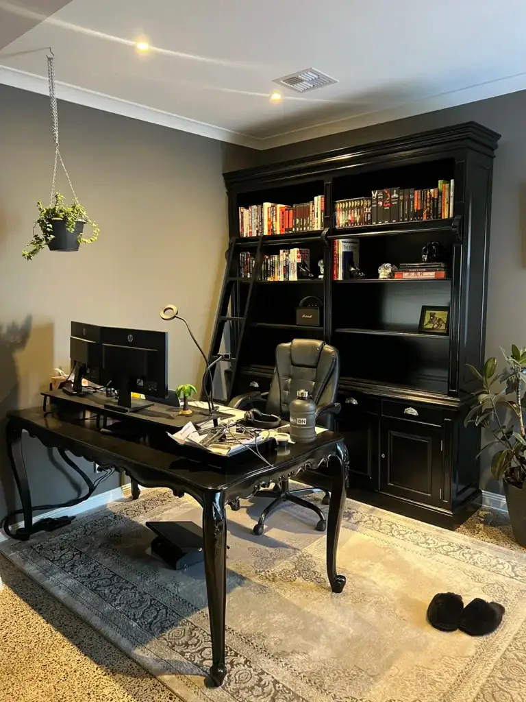 This is an image of a Black timber book shelf with sliding ladder and Black desk with HP Computers