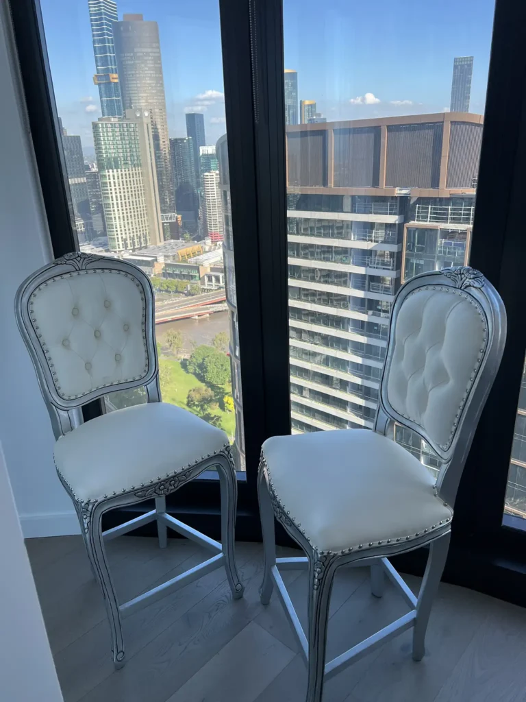 This is an image of Louis Rose signature bar stools with antique silver carved frames and cream upholstered seats from The Antique Reproduction Shop