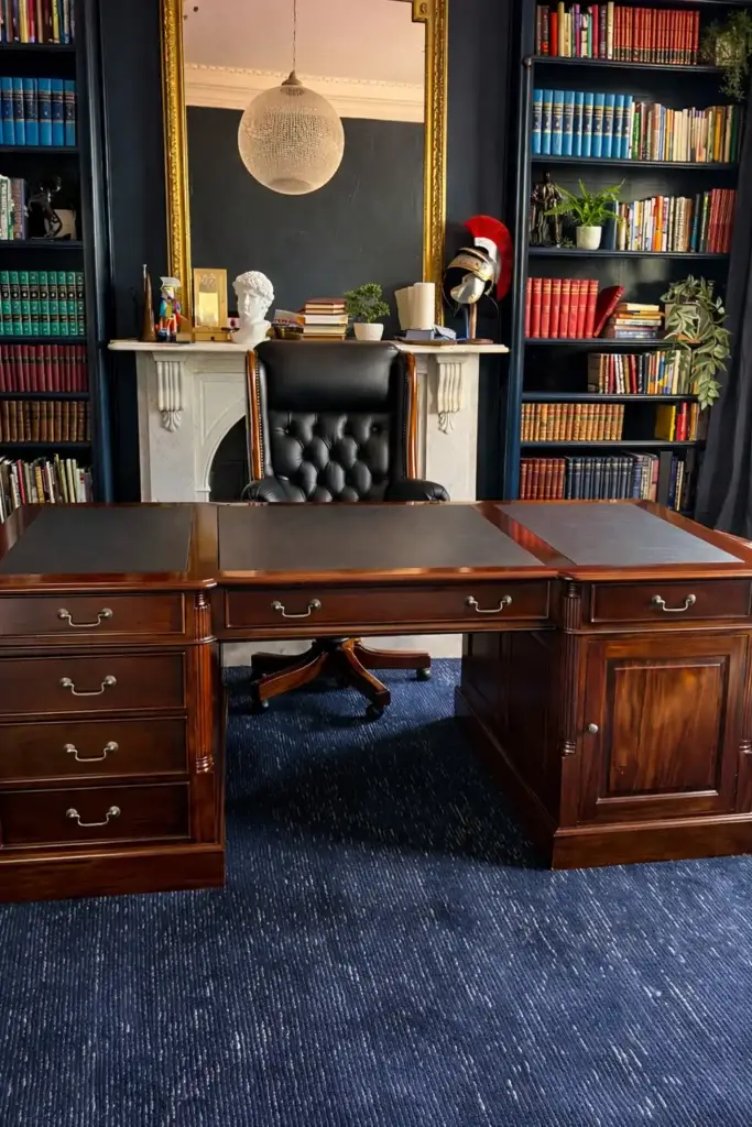 This is an image of a bespoke solid mahogany executive desk with navy leather writing inlays and antique brass hardware, handcrafted by The Antique Reproduction Shop