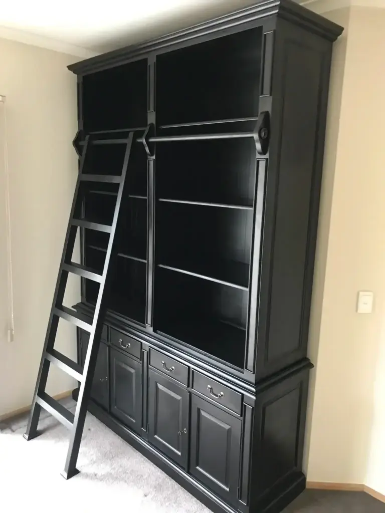 This is an image of a custom timber bookcase with a rolling ladder, handcrafted by The Antique Reproduction Shop