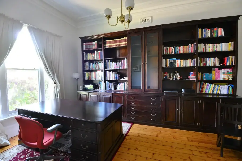 This is an image of a dark timber book shelf and book case in Melbourne, holding lots of books. The Antique Reproductions Shop, Temple & Webster, Antique Mahogany