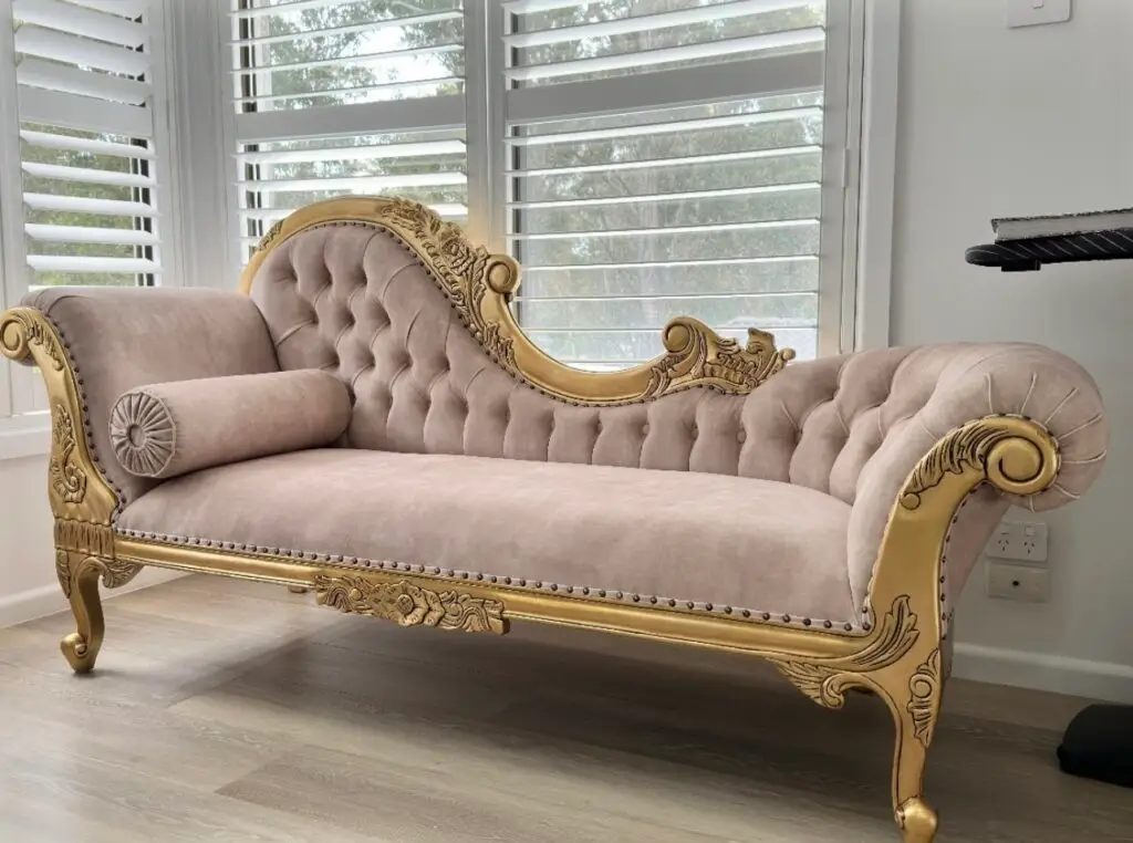 This is an image of a French Provincial chaise lounge in antique gold leaf with tufted upholstery
