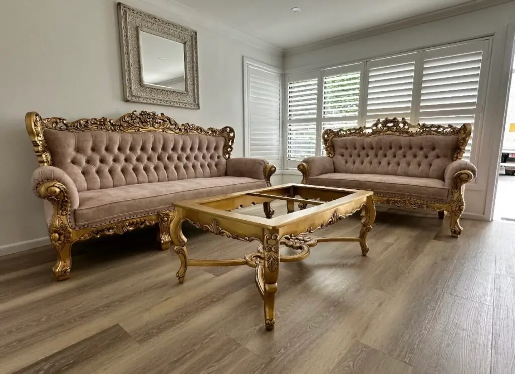 This is an image of a Rococo carved lounge suite including sofa and armchairs in antique gold finish with champagne upholstery,